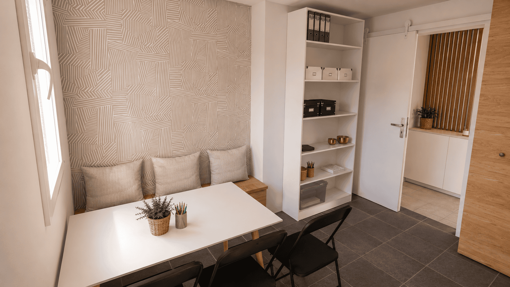 Salle de formation à domicile aménagée pour accueillir des élèves adultes avec mobilier modulable et rangements intégrés.