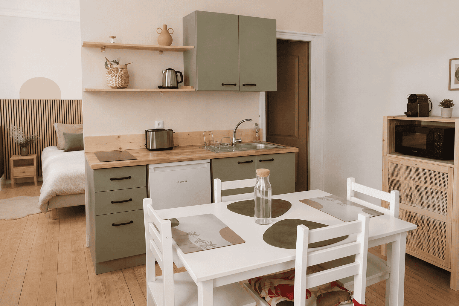 Studio de 30 m² rénové avec cuisine déplacée et création d’un coin nuit optimisant l’espace par un architecte d’intérieur.